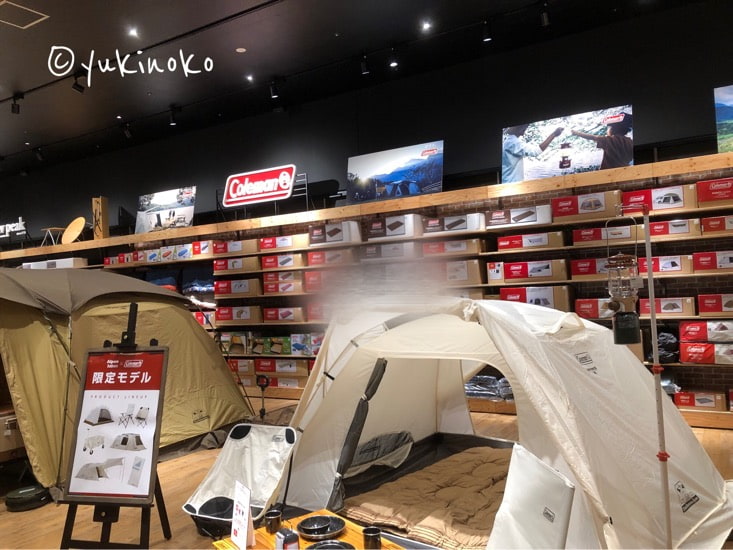アウトドアショップの店内のコールマン商品売り場にテントが展示されている