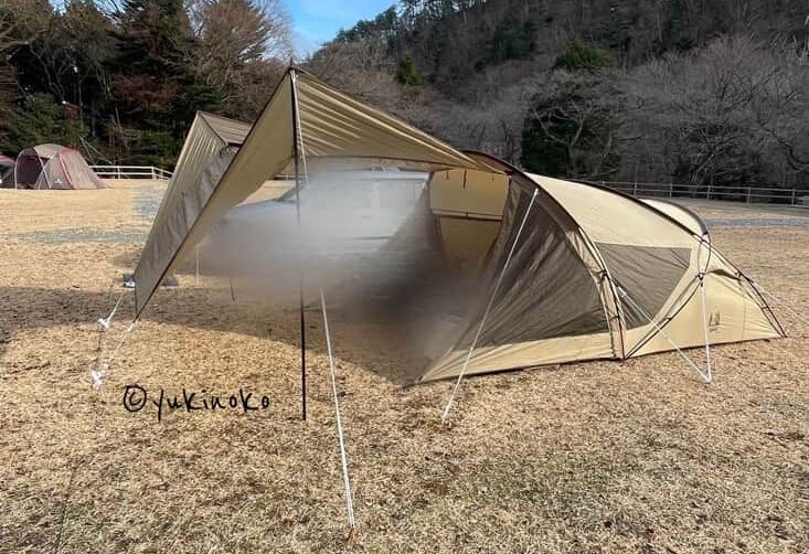 ogawaテント・シャンティRがキャンプ場の芝生の上で設営され、キャノピー部分を広げてタープのようにしている様子を正面から見て左側から撮影したもの