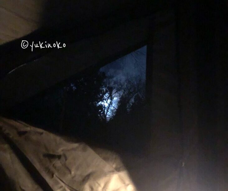 テントの隙間から夜空が見えて月と雲が見えている