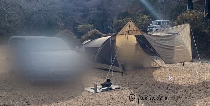 ogawaテント・シャンティRがキャンプ場の芝生の上で設営され、キャノピー部分を広げてタープのようにしている様子を正面から見て左サイドから撮影したもの
