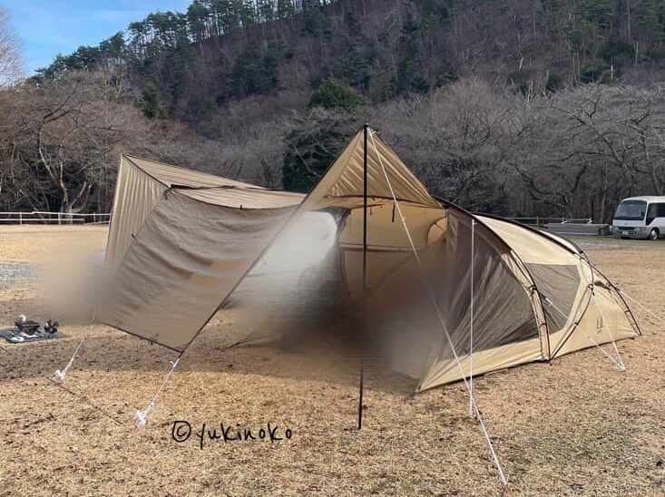 ogawaテント・シャンティRがキャンプ場の芝生の上で設営され、キャノピー部分を広げてタープのようにしている様子