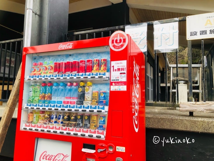 手前に赤い自販機、そのすぐ後ろにテラスのフェンスが見える