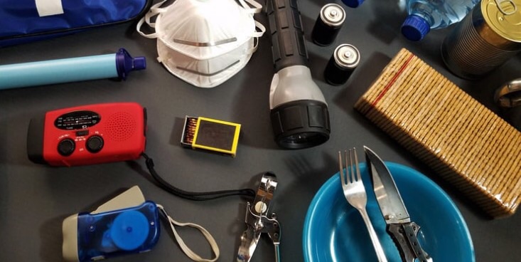 非常時用の道具や非常食がテーブルの上に並んでいる