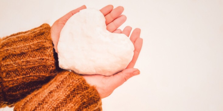 ハート型のものを両手で支えて持っている