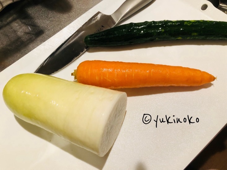 まな板の上にきゅうり、にんじん、大根が置いてある