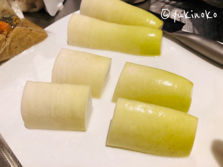 切った大根をさらに横に半分に切っている様子